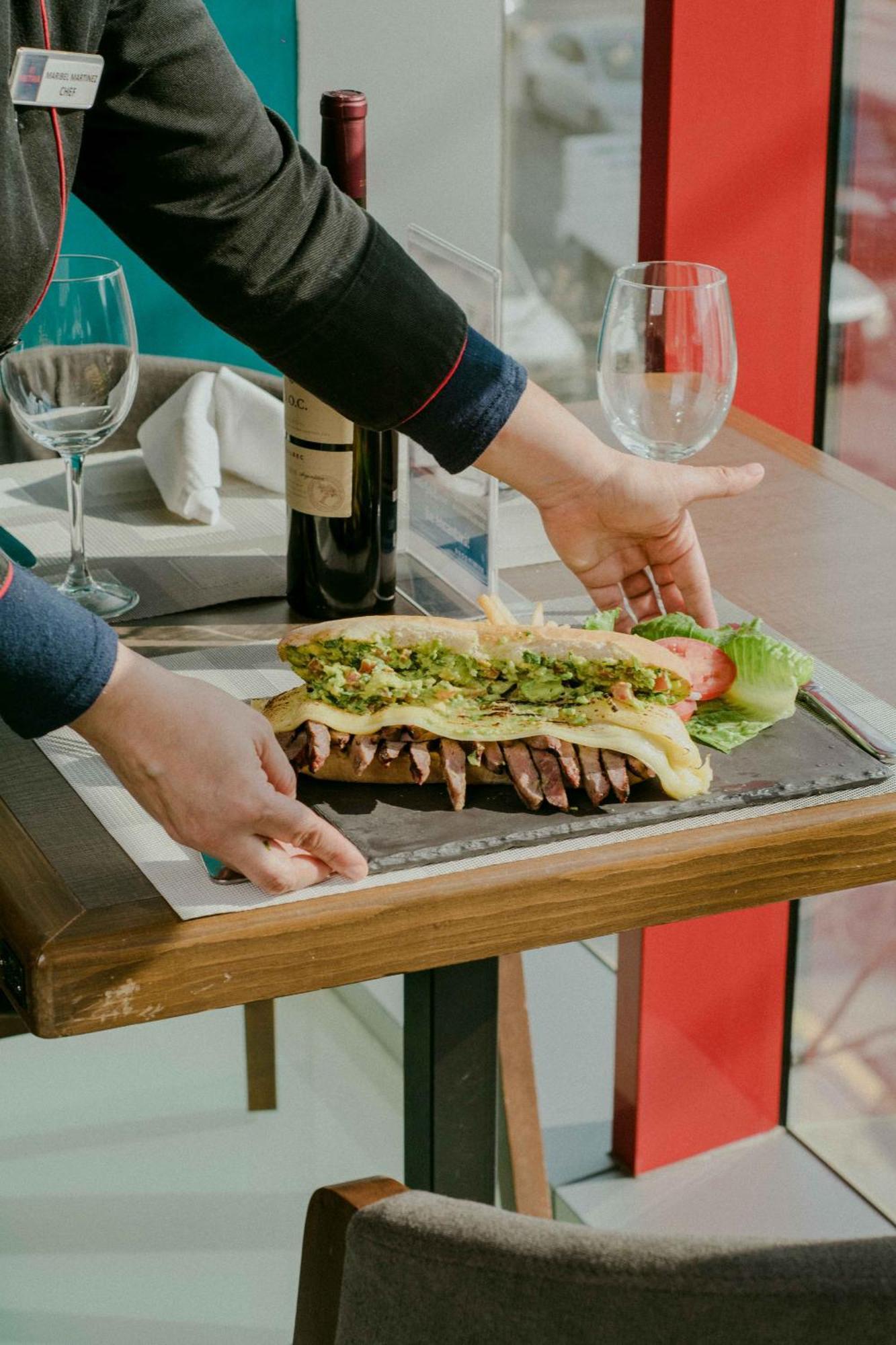 Metria Hotel เลออน ภายนอก รูปภาพ A waiter serving a steak
